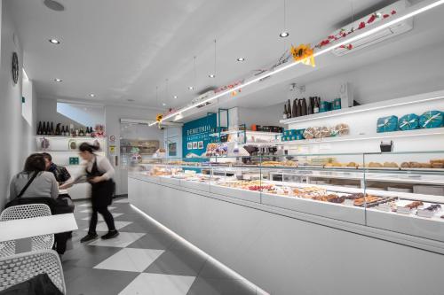 two people are standing in a bakery aisle at SUITE ANGOLO ALLA STAZIONE - Appartamento con terrazzo panoramico in Pavia