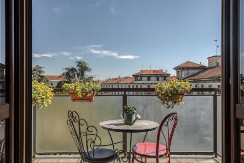 a balcony with a table and chairs and a window at ANGOLO ALLA STAZIONE SUITE - Appartamento con terrazzo panoramico in Pavia