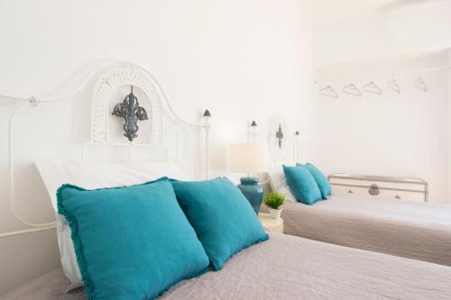 um quarto branco com 2 camas e almofadas azuis em Fabulous Apartment at UNESCO World Heritage Center em Coimbra