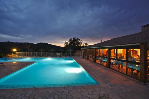 una gran piscina junto a un edificio por la noche en Camping Rondinara, en Bonifacio