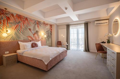 a bedroom with a large bed with a painting on the wall at Hotel Ges in Mamaia