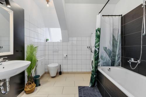 a bathroom with a tub and a sink and a toilet at COMFY Altstadt-Loft Ingolstadt in Ingolstadt