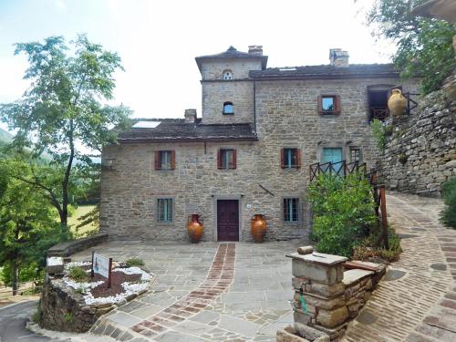 una vieja casa de piedra con una torre encima en Pieve di Cà Maggiore, en Firenzuola