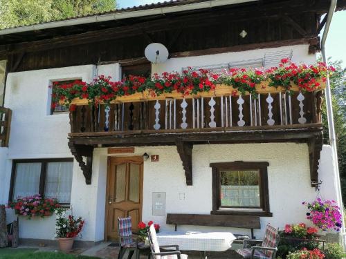 a house with a balcony with flowers on it at Ruhig am Waldrand gelegene Wohneinheit in Innsbruck