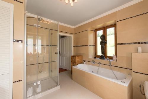 a bathroom with a tub and a glass shower at Ferienhaus Kappel mit Pool in Freiburg im Breisgau