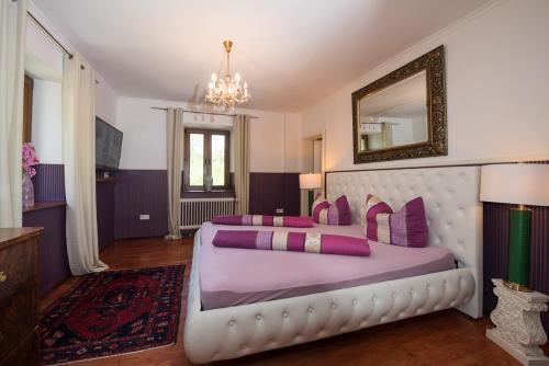 1 dormitorio con 1 cama blanca grande con almohadas moradas en Ferienhaus Kappel mit Pool, en Freiburg im Breisgau