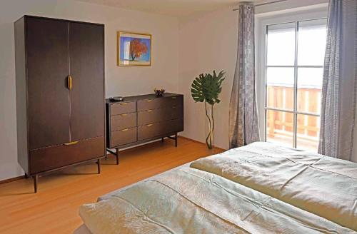 1 dormitorio con 1 cama, vestidor y ventana en Wohnung in Großgmain mit traumhaften Bergblick, en Grossgmain