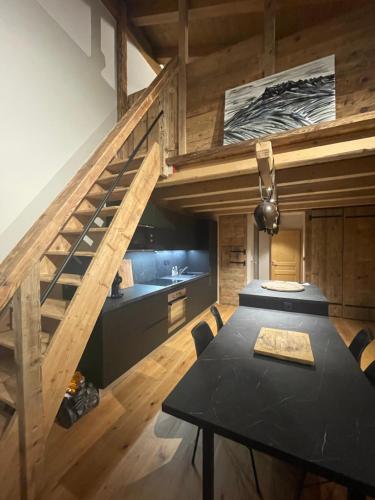 une salle à manger avec une table et un escalier dans l'établissement Appart TINDARET 6 personnes, à Châtel