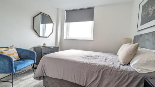 a bedroom with a bed and a chair and a window at Modern 1 Bed Apt - 15 Mins to Bham Centre in Birmingham