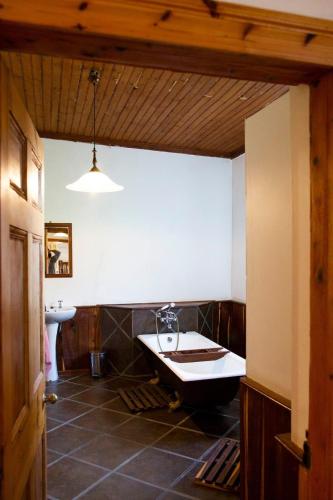 a bathroom with a bath tub and a sink at Oregon House in Riebeek-Wes