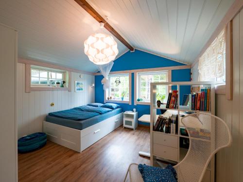 een slaapkamer met blauwe muren en een bed en een bureau bij Cozy apartment in quiet and beautiful surroundings in Svolvær