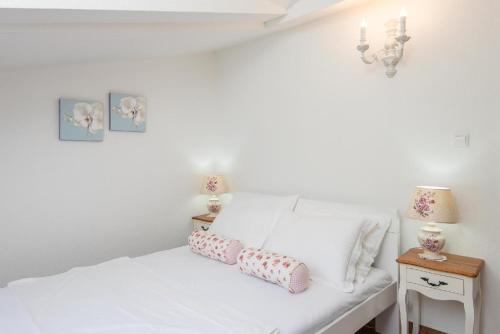 a white bed with two pillows on it at Ferienwohnung für 2 Personen ca 58 qm in Orebić, Dalmatien Süddalmatien in Orebić