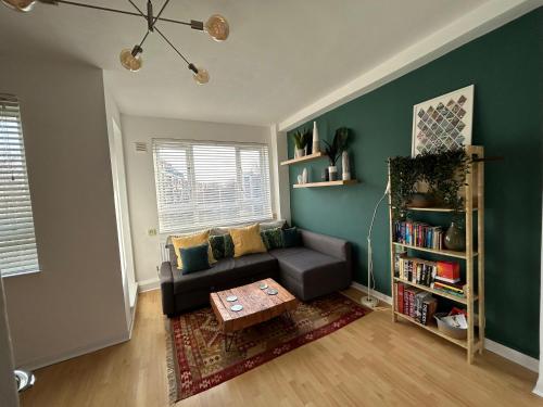 a living room with a couch and a table at Super-convenient, 3 mins to Kings Cross in London