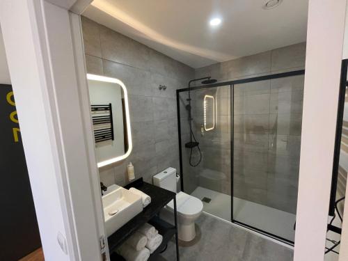 a bathroom with a shower and a toilet and a sink at Hotel Portucalense in Porto