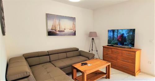 een woonkamer met een bank en een tv bij Appartement in Nin mit Terrasse, Garten und Grill in Nin
