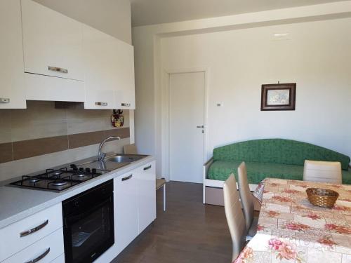 uma cozinha com uma mesa e um sofá verde em Ferienwohnung für 6 Personen ca 50 qm in Vieste, Adriaküste Italien Ostküste von Apulien - b61225 em Vieste