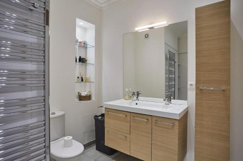 uma casa de banho com um lavatório e um WC em Apartment Arc de Triomphe/ Champs Elysée by Studioprestige em Paris