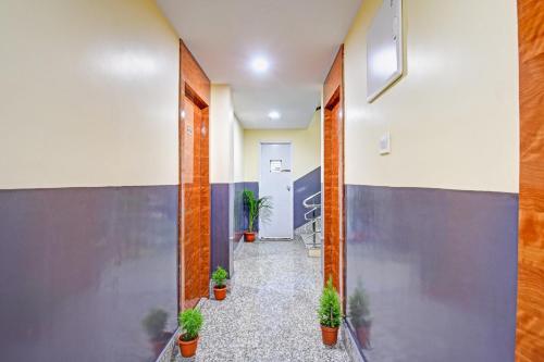 um corredor com vasos de plantas num edifício de escritórios em Collection O Aqua Tulip em Calcutá