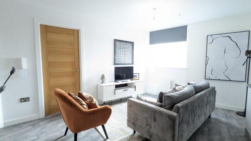 a living room with a couch and a chair at Luxury 2 Bed Apt - 15 Mins to Central Birmingham in Birmingham