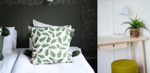 a bedroom with a bed with a green and white pillow at Gällöfsta Konferens & Herrgård in Kungsängen