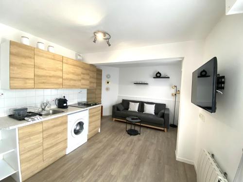 une cuisine et un salon avec un canapé dans une pièce dans l'établissement Charmant appartement 2 à 4 personnes à 200m de la plage avec wifi - ALAN, à Ploemeur