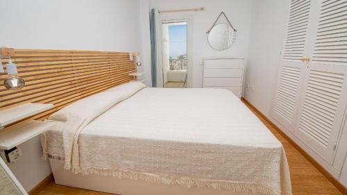 - une chambre blanche avec un lit et un miroir dans l'établissement Playas de la Duquesa 68, à Manilva