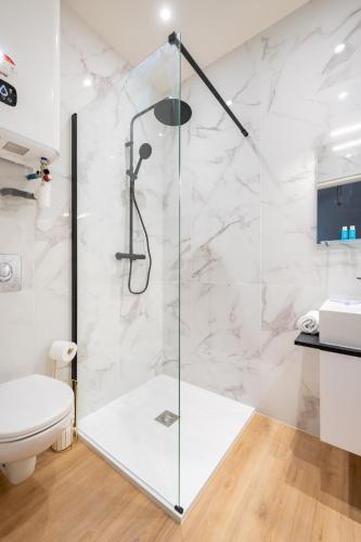 une douche avec une porte vitrée dans une salle de bain dans l'établissement Origan * Cosy * Linge hôtelier * Fibre * Calme, à La Destrousse