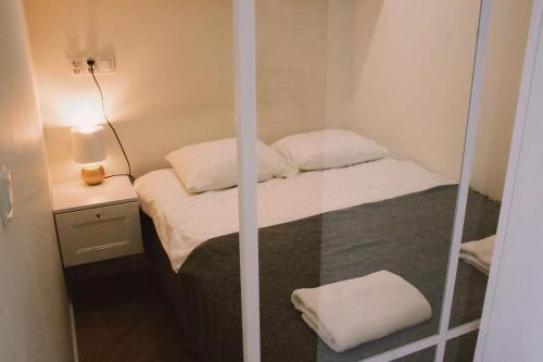 een kleine kamer met een bed en een spiegel bij Apartament No.53 in Toruń