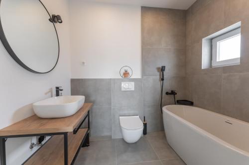 een badkamer met een bad, een wastafel en een toilet bij Bernie apartments with a pool in Zadar