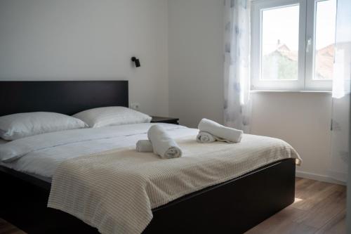 een slaapkamer met een bed met twee handdoeken erop bij Bernie apartments with a pool in Zadar