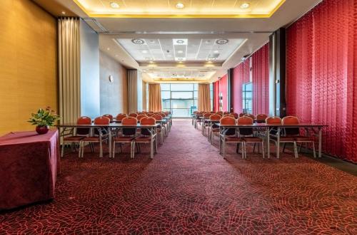 a row of tables and chairs in a room at Holiday Inn Zilina by IHG in Žilina