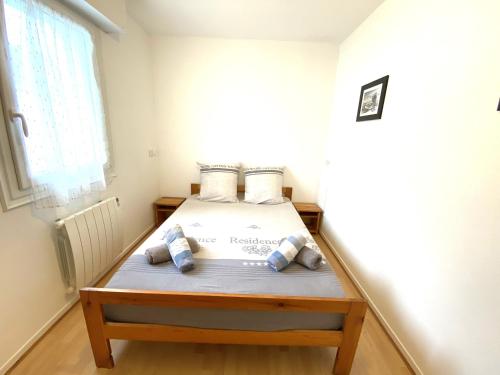 Cette petite chambre comprend un lit avec des oreillers bleus. dans l'établissement Charmant appartement 2 à 4 personnes à 200m de la plage avec wifi - ALAN, à Ploemeur