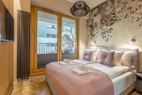 een slaapkamer met een bed met twee dienbladen erop bij Ferienwohnung am Meer, Urlaub auf der Insel Usedom, Apartment Tower 26 in Świnoujście