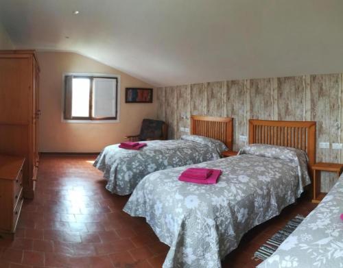Habitación de hotel con 3 camas y toallas rosas. en Santa Ana, en Pedrola