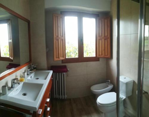 uma casa de banho com lavatório, WC e janela em Santa Ana em Pedrola