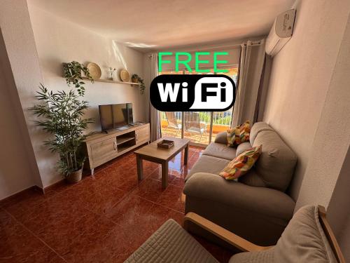 a living room with a couch and a tv at Nonna Beach Apartment Two-Bedroom Sea Views 50 m from the Beach Wifi in Rincón de la Victoria