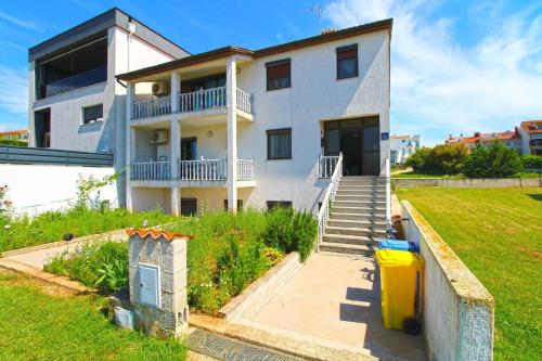 uma grande casa branca com escadas e um quintal em Ferienwohnung für 4 Personen ca 50 qm in Pula-Fondole, Istrien Istrische Riviera - b61749 em Štinjan
