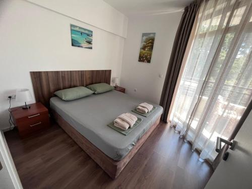 a bedroom with a bed with two towels on it at Sea and Sand Apartment Greenn Life in Sozopol