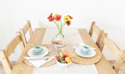 een houten tafel met een vaas van bloemen en fruit bij Ferienwohnung für 2 Personen 2 Kinder ca 50 qm in Rosignano Marittimo, Toskana Etruskische Küste in Rosignano Marittimo