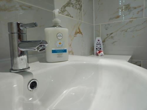 a bottle of soap sitting on a bathroom sink at Modern En-suite Doubles in Boston Town Spacious & Contemporary Rooms in Boston