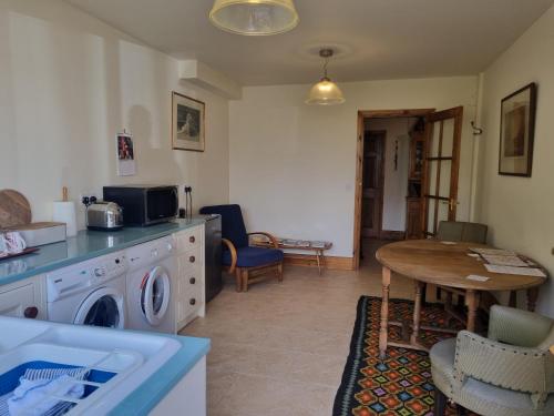 a kitchen with a washing machine and a table at Halcyon in Harrogate