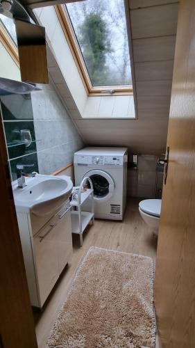 a bathroom with a sink and a washing machine at Altmarkblick in Erbenhausen