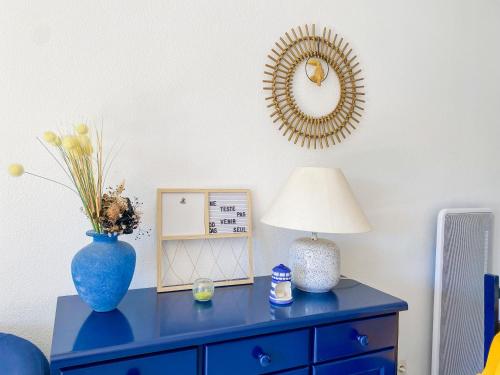 a blue dresser with a lamp and a mirror at Maison "Havre de Paix" in Vias