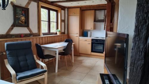 a kitchen with a table and chairs and a refrigerator at Altmarkblick in Erbenhausen