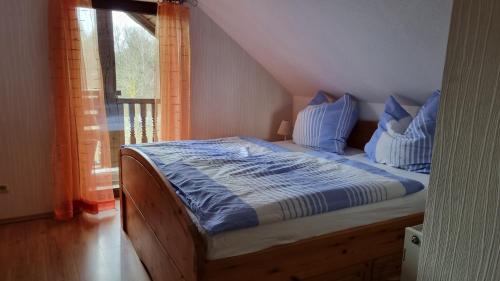 a bedroom with a bed with blue sheets and a window at Altmarkblick in Erbenhausen