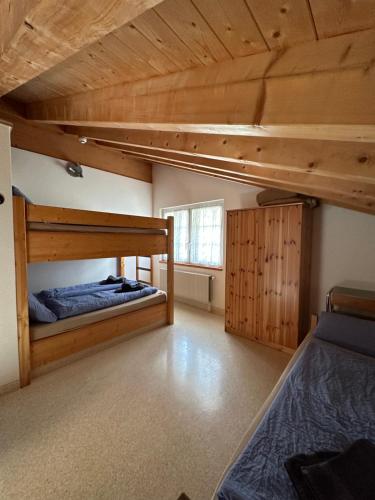 a bedroom with two bunk beds and a window at Touristenheim Bergfreude in Leukerbad