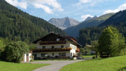a house in a field with mountains in the background at Große Wohnung in Bach mit Eigenem Balkon in Bach