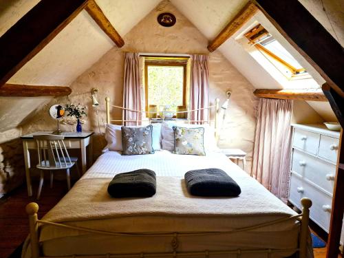a bedroom with a large bed in a attic at Y Beudy Llangrannog in Llangranog