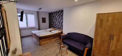 a room with a bed and a couch and a chair at Gästehaus Kretschmann in Zeltingen-Rachtig
