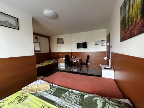 a bedroom with a bed and a dining room at Penzión Rozália in Košice